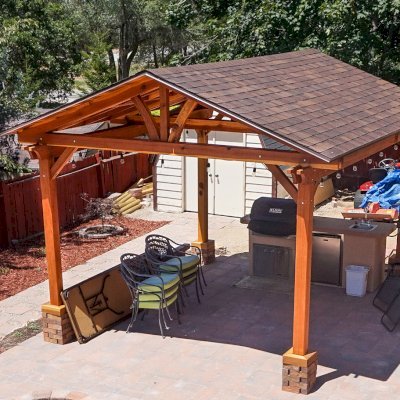Del Norte Outdoor Kitchen Pavilion (Options: 16' L x 14' W, California Redwood [Mature Redwood Posts], Unattached, 4-Post Anchor Kit for High-Wind, Electrical Wiring Trim for 1 Post, 9.5' Posts, No Ceiling Fan Base, No Privacy Panels, No Curtain Rods, Transparent Premium Sealant). Shingles not Included. Photo Courtesy of K. Hyde of Ogden, Utah.