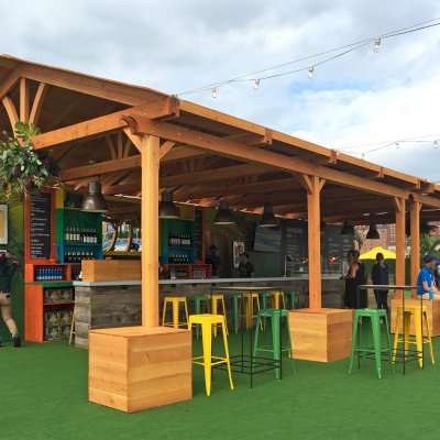 Rio on the Hudson: Olympic Village in NYC. 2 Del Norte Outdoor Kitchen Pavilions (Options: 25' L x 20' W, Douglas-fir, We used 2' x 2' x 2'  Concrete Blocks to Anchor the Structure Because it is a Temporary Installation, Covered the Concrete Blocks with Wooden Boxes, No Ceiling Fan Base, Transparent Premium Sealant). Photo Courtesy of A. Fisher of New York, NY.