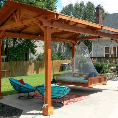 Del Norte Outdoor Kitchen Pavilion (Options: 18' L x 12' Triangle Base W, California Redwood, Unattached, 4-Post Anchor Kit for Concrete, No Electrical Wiring, 9 ft Post Height, No Ceiling Fan Bse, No Privacy Panels, 4 Curtain Rods,Transparent Sealant) with a Custom Day Bed. Photo Courtesy of Kym C. of Charlotte, NC.