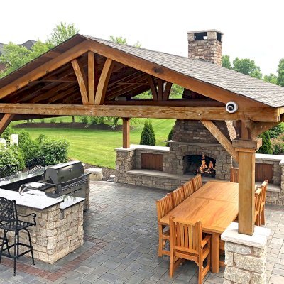 Del Norte Outdoor Kitchen Pavilion (Options: 20' L x 20' W, California Redwood, 4-Post Anchor Kit for High-Wind, 1 Ceiling Fan Base, Transparent Premium Sealant, Custom Cut Out in the Back Overhang to Fit the Fireplace). Photo Courtesy of Tom Mislenkov of Chesterton, Indiana.