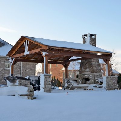 Del Norte Outdoor Kitchen Pavilion (Options: 20' L x 20' W, California Redwood, 4-Post Anchor Kit for High-Wind, 1 Ceiling Fan Base, Transparent Premium Sealant, Custom Cut Out in the Back Overhang to Fit the Fireplace). Photo Courtesy of Tom Mislenkov of Chesterton, Indiana.