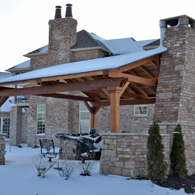 Del Norte Outdoor Kitchen Pavilion (Options: 20' L x 20' W, California Redwood, 4-Post Anchor Kit for High-Wind, 1 Ceiling Fan Base, Transparent Premium Sealant, Custom Cut Out in the Back Overhang to Fit the Fireplace). Photo Courtesy of Tom Mislenkov of Chesterton, Indiana.