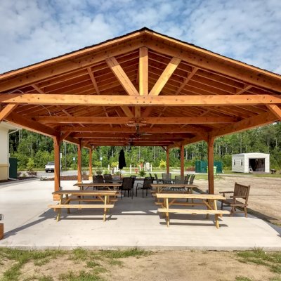 Del Rio Cathedral Ceiling Thick Timber Pavilion (Options: 60' L x 24' W, Douglas-fir, 4-Post Anchor Kit for High-Wind, 3 Ceiling Fan Bases, 8 Electrical Wiring Trim Kit, No Post Decorative Trims, Transparent Premium Sealant). Photo Courtesy of the st. Francis of Assisi Roman Catholic Church Mission of Yulee, FL [86000 St. Francis Way, Yulee, Florida 32097].
