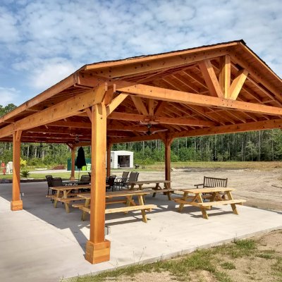 Del Rio Cathedral Ceiling Thick Timber Pavilion (Options: 60' L x 24' W, Douglas-fir, 4-Post Anchor Kit for High-Wind, 3 Ceiling Fan Bases, 8 Electrical Wiring Trim Kit, No Post Decorative Trims, Transparent Premium Sealant). Photo Courtesy of the st. Francis of Assisi Roman Catholic Church Mission of Yulee, FL [86000 St. Francis Way, Yulee, Florida 32097].