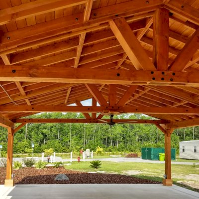 Del Rio Cathedral Ceiling Thick Timber Pavilion (Options: 60' L x 24' W, Douglas-fir, 4-Post Anchor Kit for High-Wind, 3 Ceiling Fan Bases, 8 Electrical Wiring Trim Kit, No Post Decorative Trims, Transparent Premium Sealant). Photo Courtesy of the st. Francis of Assisi Roman Catholic Church Mission of Yulee, FL [86000 St. Francis Way, Yulee, Florida 32097].
