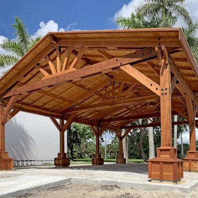 Custom Del Rio Cathedral Ceiling Thick Timber Pavilion (Options: 36' L x 24' Triangle Base W, No Privacy Panels, Douglas-fir, 10' ft Height, Electrical Wiring Trims for All Posts, With Custom Anchors and Hardware, Custom Trim Boxes at the Bottom of the Posts (Boots), 3 Ceiling Fan Bases, No Curtain Rods, Transparent Premium Sealant). This Pavilion can be seen at the South Florida Science Center, 4801 Dreher Trail N, West Palm Beach, FL 33405.