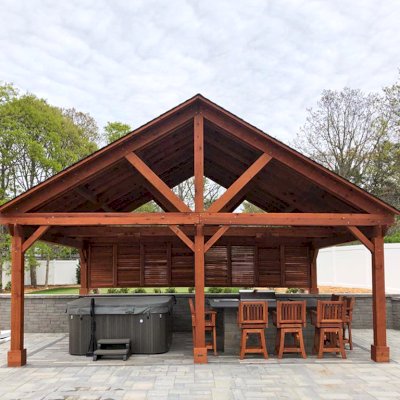 Del Rio Cathedral Ceiling Thick Timber Pavilion  (Options: 18' L x 26' W, California Redwood, 6-Post Anchor Kit for Concrete, Electrical Wiring Trim for 2 Posts, 9.5' Posts, 2 Ceiling Fan Bases, No Privacy Panels, No Curtain Rods, Transparent Premium Sealant, with Extra Knee Braces on the Back by Custom Request). Photo Courtesy of B. Poutre of North Falmouth, Massachusetts.