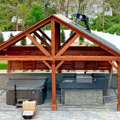 Del Rio Cathedral Ceiling Thick Timber Pavilion  (Options: 18' L x 26' W, California Redwood, 6-Post Anchor Kit for Concrete, Electrical Wiring Trim for 2 Posts, 9.5' Posts, 2 Ceiling Fan Bases, No Privacy Panels, No Curtain Rods, Transparent Premium Sealant, with Extra Knee Braces on the Back by Custom Request). Photo Courtesy of B. Poutre of North Falmouth, Massachusetts.