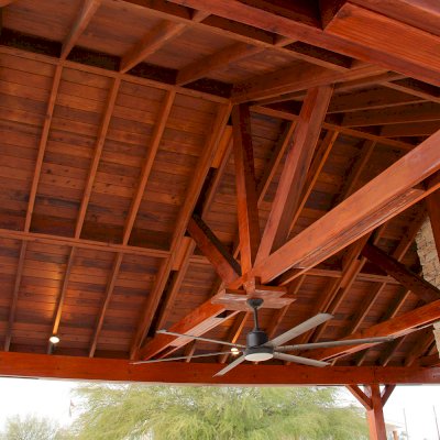 Del Rio Cathedral Ceiling Thick Timber Pavilion (Options: 42' L x 22' Triangle Base W, No Privacy Panels, Mature Redwood, 10' ft Height, Electrical Wiring Trim for 1 Post, 6-Post Anchor Kit for High-Wind, No Post Decorative Trim, 2 Ceiling Fan Bases, No Curtain Rods, Transparent Premium Sealant). Note: Fireplace and kitchen counter was added after the Pavilion was installed by a Mason.  Forever Redwood does not do masonry work, but our designs can incorporate them.