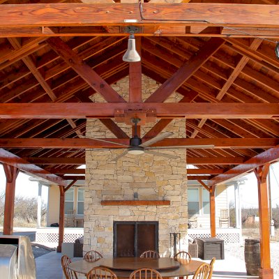 Del Rio Cathedral Ceiling Thick Timber Pavilion (Options: 42' L x 22' Triangle Base W, No Privacy Panels, Mature Redwood, 10' ft Height, Electrical Wiring Trim for 1 Post, 6-Post Anchor Kit for High-Wind, No Post Decorative Trim, 2 Ceiling Fan Bases, No Curtain Rods, Transparent Premium Sealant). Note: Fireplace and kitchen counter was added after the Pavilion was installed by a Mason.  Forever Redwood does not do masonry work, but our designs can incorporate them.