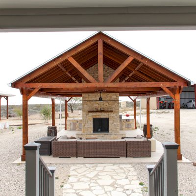 Del Rio Cathedral Ceiling Thick Timber Pavilion (Options: 42' L x 22' Triangle Base W, No Privacy Panels, Mature Redwood, 10' ft Height, Electrical Wiring Trim for 1 Post, 6-Post Anchor Kit for High-Wind, No Post Decorative Trim, 2 Ceiling Fan Bases, No Curtain Rods, Transparent Premium Sealant). Note: Fireplace and kitchen counter was added after the Pavilion was installed by a Mason.  Forever Redwood does not do masonry work, but our designs can incorporate them.