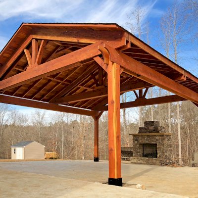 Del Rio Cathedral Ceiling Thick Timber Pavilion (Options: 22' x 22', California Redwood, 4-Post Anchor Kit for High-Wind, With 2 Ceiling Fan Bases, Electrical Wiring Trim Kit for 1 Post, No Post Decorative Trim, Transparent Premium Sealant, 1 1/2" x 11 1/4" Supports and Rafters by Custom Request). Has some customized details. Photo Courtesy of B. Morales of Clayton, NC.