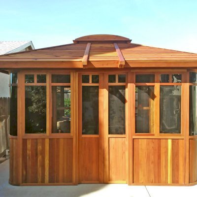 DIY Wood Gazebo (14' L, 12' W, California Redwood, All Sliding Windows with Screens, 4' x 6' Skylight, 36" H Siding Below Windows, Vertical Siding, Japanese Doors with Screens, No Flooring, Transparent Premium Sealant). Photo Courtesy of B. Adkisson of Sacramento, CA. XL Custom Roof per Customer Request.