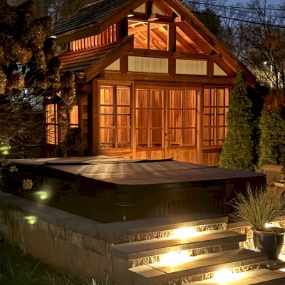 Custom Dream Gazebos (Options: 9 ft Wall Height, 10' L, 14' W, California Redwood, Combination of Sliding Windows with Screens and Fixed Windows, No Skylight, 36" H Siding Below Windows, Vertical Siding, Roof Pitch 8:12, Japanese Doors with Screens, No Floor [Installed on an Existing Deck], Shiplap Roof, Transparent Premium Sealant). Photo Courtesy of J. & R. Griess of Omaha, NE.