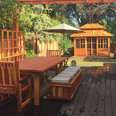 Dream Gazebos (Options: 7ft Wall Height, 12' L, 10' W, California Redwood, All Sliding Windows with Screens, 4' x 4' Skylight, 30" H Siding Below Windows, Horizontal Siding, Japanese Doors, Complete Floor, Set of Shingles, Transparent Premium Sealant). Photo also shows a San Francisco Patio Table with 2 Ruth Chairs, a Storage Bench and Mendocino Planters with Trellises. Photo Courtesy of Tina Phi of Palo Alto, CA. 