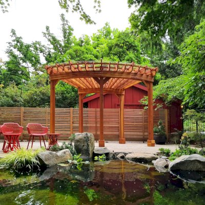 Fan Shaped Pergola Kit (Options: 15' x 18', California Redwood, Open Roof Slats at 12in, With Transparent Rain Guard, Electrical Wiring Trim Kit for 1 Post, Post Anchor Kit for Concrete, No Ceiling Fan Base, 10' Posts, No Curtain Rods, Transparent Premium Sealant). Photo Courtesy of G. Fish of Vancouver, WA.