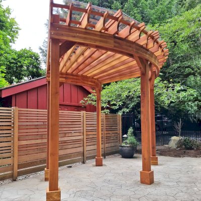 Fan Shaped Pergola Kit (Options: 15' x 18', California Redwood, Open Roof Slats at 12in, With Transparent Rain Guard, Electrical Wiring Trim Kit for 1 Post, Post Anchor Kit for Concrete, No Ceiling Fan Base, 10' Posts, No Curtain Rods, Transparent Premium Sealant). Photo Courtesy of G. Fish of Vancouver, WA.