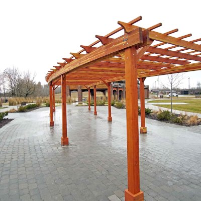 Fan Shaped Pergola Kit (Options: 50' x 14', California Redwood, Roof Slats at 18", No Electrical Wiring Trim Kit, 9-Post Anchor Kit for Concrete, No Ceiling Fan Base, 9.5' Posts, No Curtain Rods, Transparent Premium Sealant). Photo Courtesy of Metroparks Toledo of Toledo, OH.