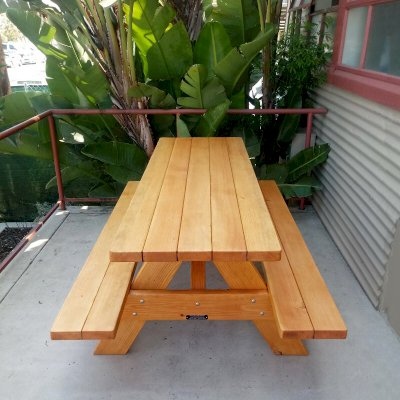 Forever Picnic Tables (Attached Benches) (Options: 6' L, 24" W (Custom details: Benches and tabletop narrower [benches only 10" W vs 11 1/2" W standard - tabletop only 24" W vs 28 1/4" standard]) and placed closer to table to create more walking room in limited space), Attached Side Benches, Douglas-fir, Standard Tabletop, Slightly Rounded Corners, No Umbrella Hole, Transparent Premium Sealant). Photo Courtesy of T. Stockton of Ventura, CA.
