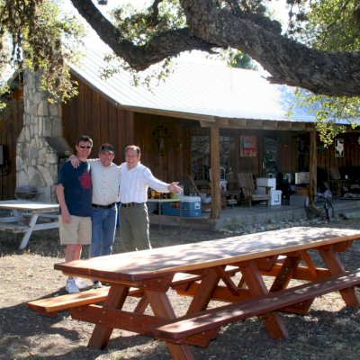 Forever Picnic Tables (Attached Benches) (Options: 12' L, 34 1/2" W, Side Benches, Mature Redwood, Standard Tabletop, Rounded Corners, No Umbrella Hole, Transparent Premium Sealant). Photo Courtesy of Mr. Pat Ankney, W&M Ranch, Camp Wood, TX. 