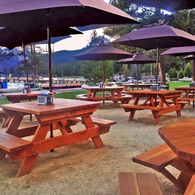 Forever Picnic Tables (Attached Benches) (Options: 4' L, 42" W, Side Benches, California Redwood, Standard Tabletop, Squared Corners, Umbrella Hole, Transparent Premium Sealant). Photo also shows some Octagonal Picnic Tables. Photo Courtesy of Redfish Lake Lodge located in 401 Redfish lake Lodge Rd, 5 Miles S. of Stanley, Hwy 75, Stanley, Idaho, 83278.