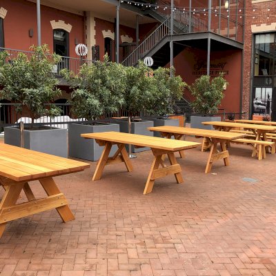 Forever Picnic Tables (Unattached Benches) (Options: 7' L, 34 ½in W, Some Table with No Seating and Some with Side Benches, Douglas-fir,1 Full Length Side Bench Per Side, Standard Tabletop, Slightly Rounded Corners, No Umbrella Hole, Transparent Premium Sealant). Photo also shows some Mendocino and Napa Planters. Photo Courtesy of A. Frost. Installed at Ghirardelli Square, West Plaza Beer Garden, located at 900 North Point Street at the corner of Beach & Larkin Streets, San Francisco, CA.