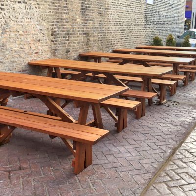Forever Picnic Tables (Unattached Benches) (Options: 10', 34 ½in W, Side Benches, Mature Redwood, 1 Full Length Side Bench Per Side, Standard Tabletop, Squared Corners, 2in Umbrella Hole, Transparent Premium Sealant). Standard design is with 5 3/4" wide boards. The tabletops in this photo were built for the restaurant by request using bookend construction (where 2 standard width 5 3/4" wide boards are tongue and grooved together to appear as one wider 11 1/2" wide board). If you would like this effect for your tables, just add a note saying want bookend detail added to your order (no extra charge to do this). Photo courtesy of M. Piekarz of Chicago, IL.