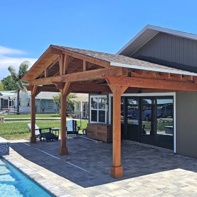 Forever Porch Pavilion (Options: 12' L x 25' W, Douglas-fir, 3-Post Anchor Kit for High-Wind, Electrical Wiring Trim for All Posts, 9 ft Posts Height, 2 Fascia Boards, No Post Decorative Trims, 2 Ceiling Fan Bases, No Curtain Rods, No Privacy Panels, Transparent Premium Sealant). Photo Courtesy of B. Carman of Ormond Beach, FL.