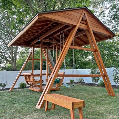 Jean's Ultimate Swing Set (Options: Mosaic Douglas-Fir with Mosaic Mature Redwood Roof, Ensenada Face to Face Seats, with 1 Co-Polymer Standard & 1 Full Bucket Swing Seat in Green Color, with Beverage Armrests, Extra Wide Roof, with Kid's Platform/Side Table, No, Engraving, Transparent Premium Sealant). Photo Courtesy of M. & V. Zayas of Clifton, NJ.