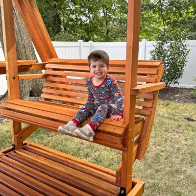 Jean's Ultimate Swing Set (Options: Mosaic Douglas-Fir with Mosaic Mature Redwood Roof, Ensenada Face to Face Seats, with 1 Co-Polymer Standard & 1 Full Bucket Swing Seat in Green Color, with Beverage Armrests, Extra Wide Roof, with Kid's Platform/Side Table, No, Engraving, Transparent Premium Sealant). Photo Courtesy of M. & V. Zayas of Clifton, NJ.