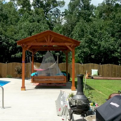 Jhoola Day Bed Swing Sets (Options: 7' L, 60" W, Seat Only, California Redwood, All Beam Hanging Hardware, Add 3 Railings (North, South and extra one, East or West), Day Bed Style, No Cushion, Transparent Premium Sealant). Also shows a Del Norte Pavilion.