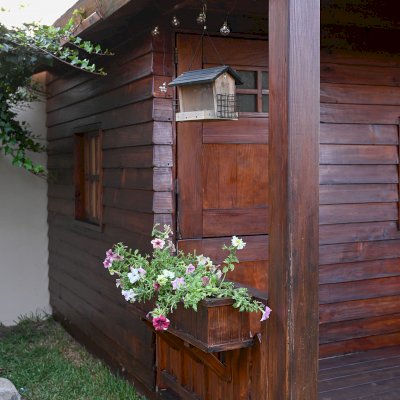 Kid's Backyard Cabin (Options: 12ft L x 8ft W, 7ft Wall H, Douglas-Fir, 4ft Front Porch Size [Included in the Overall Length], Interior Decking, Transparent Premium Sealant). Photo shows structure recently resealed after 6 years of loving service.