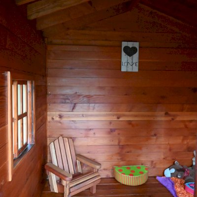 Kid's Backyard Cabin (Options: 12ft L x 8ft W, 7ft Wall H, Douglas-Fir, 4ft Front Porch Size [Included in the Overall Length], Interior Decking, Transparent Premium Sealant). Photo shows structure recently resealed after 6 years of loving service.