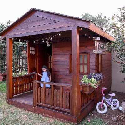 Kid's Backyard Cabin (Options: 12ft L x 8ft W, 7ft Wall H, Douglas-Fir, 4ft Front Porch Size [Included in the Overall Length], Interior Decking, Transparent Premium Sealant). Photo shows structure recently resealed after 6 years of loving service.