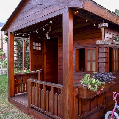 Kid's Backyard Cabin (Options: 12ft L x 8ft W, 7ft Wall H, Douglas-Fir, 4ft Front Porch Size [Included in the Overall Length], Interior Decking, Transparent Premium Sealant). Photo shows structure recently resealed after 6 years of loving service.