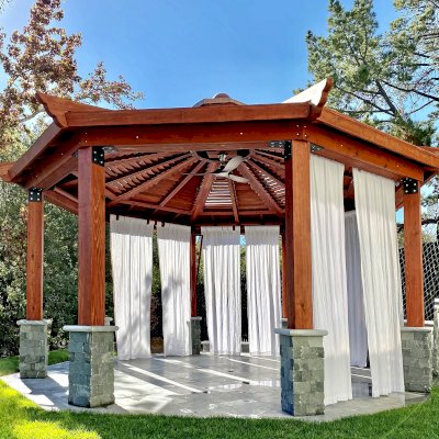 Custom Kikue's Pavilion (Options: 20' Diameter, Mature Redwood, with a Ceiling Fan Base, with Louvers and Rain Guard, Posts Anchor Kit for High-Wind, Transparent Premium Sealant). Photo Courtesy of C. Young of Los Gatos, CA.