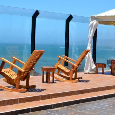 2 The Lighthouse Rocking Chair (Options: California Redwood, No Cushion, Transparent Premium Sealant). Photo also shows Round Side Table and Folding Adirondack Chair with Ottoman.