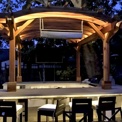 Marin Outdoor Kitchen Pergola (Options: 14' L x 14' Arc W, California Redwood, Unattached, 2 Post Electrical Wiring Trim, 4-Post Anchor Kit for Stone, No Ceiling Fan Base, No Privacy, No Curtain Rods, 9 ft Post Height (front posts wrapped with masonry), Transparent Premium Sealant). Photo Courtesy of C. Funkhouser of Hillsborough, California.