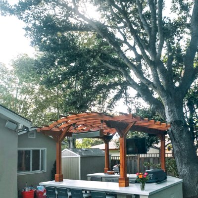 Marin Outdoor Kitchen Pergola (Options: 14' L x 14' Arc W, California Redwood, Unattached, 2 Post Electrical Wiring Trim, 4-Post Anchor Kit for Stone, No Ceiling Fan Base, No Privacy, No Curtain Rods, 9 ft Post Height (front posts wrapped with masonry), Transparent Premium Sealant). Photo Courtesy of C. Funkhouser of Hillsborough, California.