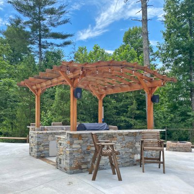 Marin Outdoor Kitchen Pergola (Options: 14' L x 15' Arc W, Douglas-fir, Unattached, 1 Post Electrical Wiring Trim, 4-Post Anchor Kit for High-Wind, No Ceiling Fan Base, No Privacy, No Curtain Rods, 9.5 ft Post Height (posts wrapped with masonry), Transparent Premium Sealant). Photo Courtesy of Bill & Lori O’Mara of Marion, North Carolina.