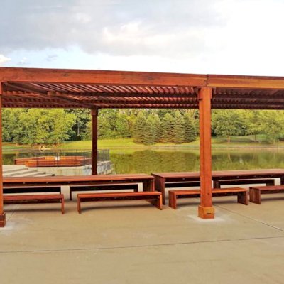 Maynard Modern Redwood Patio Table (Options: 15' L, 42" W Tabletop, Side Benches, California Redwood, 2 Half Length Maynard Benches Per Side, Standard Tabletop, No Umbrella Hole, Transparent Premium Sealant). Tables Under a Silverado Modern Pergola. Photo Courtesy of A. Arena of Morristown, New Jersey.