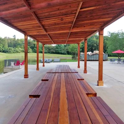 Maynard Modern Redwood Patio Table (Options: 15' L, 42" W Tabletop, Side Benches, California Redwood, 2 Half Length Maynard Benches Per Side, Standard Tabletop, No Umbrella Hole, Transparent Premium Sealant). Tables Under a Silverado Modern Pergola. Photo Courtesy of A. Arena of Morristown, New Jersey.