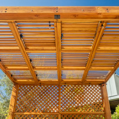 Modern Louvered Garden Pergola (Options: 12' L x 12' W, 8'' x 8'' Posts, Mobile Louvers, Douglas-fir, with 1 Lattice Privacy Wall, Electrical Wiring Trim for 1 Post, Without Fascia, No Curtain Rods, 4 Post Anchor Kit for Wood, No Post Decorative Trims, No Ceiling Fan Base, Transparent Premium Sealant). Photo Courtesy of S. Weinswig of Los Angeles, CA.