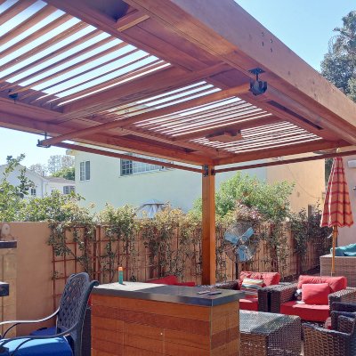 Modern Louvered Garden Pergola (Options: 25' L x 10' W, 8'' x 8'' Posts, Mobile Louvers, Douglas-fir, No Privacy Wall, Electrical Wiring Trim for 2 Posts, Without Fascia, 4 Curtain Rods, 4 Post Anchor Kit for Concrete, No Post Decorative Trims, 2 Ceiling Fan Bases, Transparent Premium Sealant). Photo Courtesy of B. Hamideh of Studio City, CA.