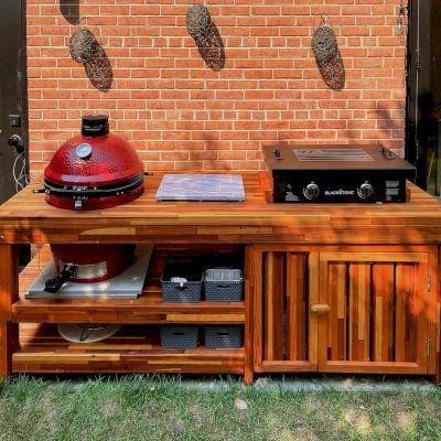 Custom Outdoor Table With Built In Grill (Options: 8' L, 32" W, Mosaic Redwood, Two Shelves, Slightly Rounded Corners, 34"H, 22-inch Grill Opening, Extra Opening for Griddle, Right Side Enclosed and One Door Added by Custom Request, Transparent Premium Sealant). Legs aligned to tabletop by custom request. Photo Courtesy of S. McCord of 