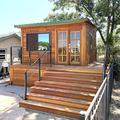 Custom Palo Alto Backyard Cabin (Options: 18' L, 16' W, With 19' x 19' Structural Deck with Steps, California Redwood for Exterior Finished, Douglas-fir Internal Walls and Framing, Double Door, Slidding Windows, Windows Purchased Locally, With Two 2' x 2' Skylights, Metal Roof, Electrical Wire Trim on the Walls, Transparent Premium Sealant). Photo Courtesy of R. and M. Hegwood of Ceres, CA.