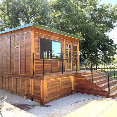 Custom Palo Alto Backyard Cabin (Options: 18' L, 16' W, With 19' x 19' Structural Deck with Steps, California Redwood for Exterior Finished, Douglas-fir Internal Walls and Framing, Double Door, Slidding Windows, Windows Purchased Locally, With Two 2' x 2' Skylights, Metal Roof, Electrical Wire Trim on the Walls, Transparent Premium Sealant). Photo Courtesy of R. and M. Hegwood of Ceres, CA.