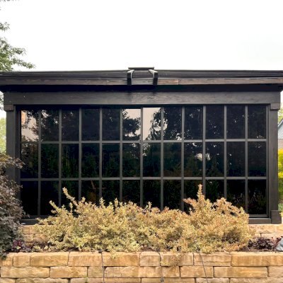 Sun Gazebo with Sliding Doors (Options: Custom Size 18' L x 15' W, Douglas-Fir, 8 ft Wall Height, 3 Sliding Walls and One Fixed Wood Wall, Without Skylight, Complete Floor, 1 Ceiling Fan Base, 1 TV Mount, Shiplap Roof, Black Stain Premium Sealant). Photo Courtesy of W. Geisert of Troy, MI.