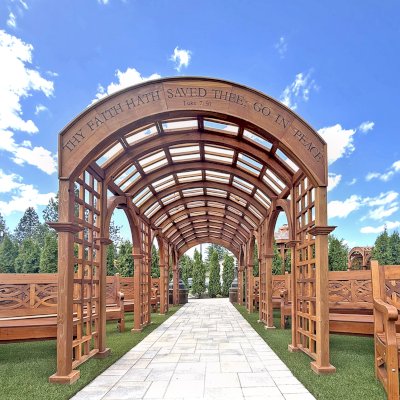 Victorian Trellis (Options: 22' x 8', California Redwood, Custom Engraving, Transparent Premium Sealant). Photo Also Shows Several Hennell Garden Benches. Trellis Installed in Faith Walk Community Fitness Park in Coeur d'Alene, Idaho.