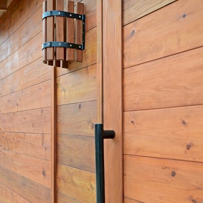 Raul’s Rad Redwood Sauna (Options: 11' W, 8' D, 11' H, California Redwood (for Interiors) & Mature Redwood (for Exteriors), Pitch Roof for Exterior Areas, "L" Shape Bench (2 levels), Transparent Premium Sealant).